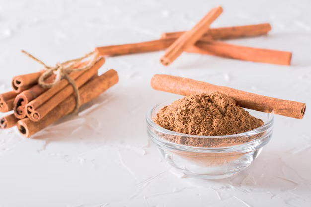 cinnamon-sticks-tied-with-rope-ground-cinnamon-bowl-lie-table_107288-2625