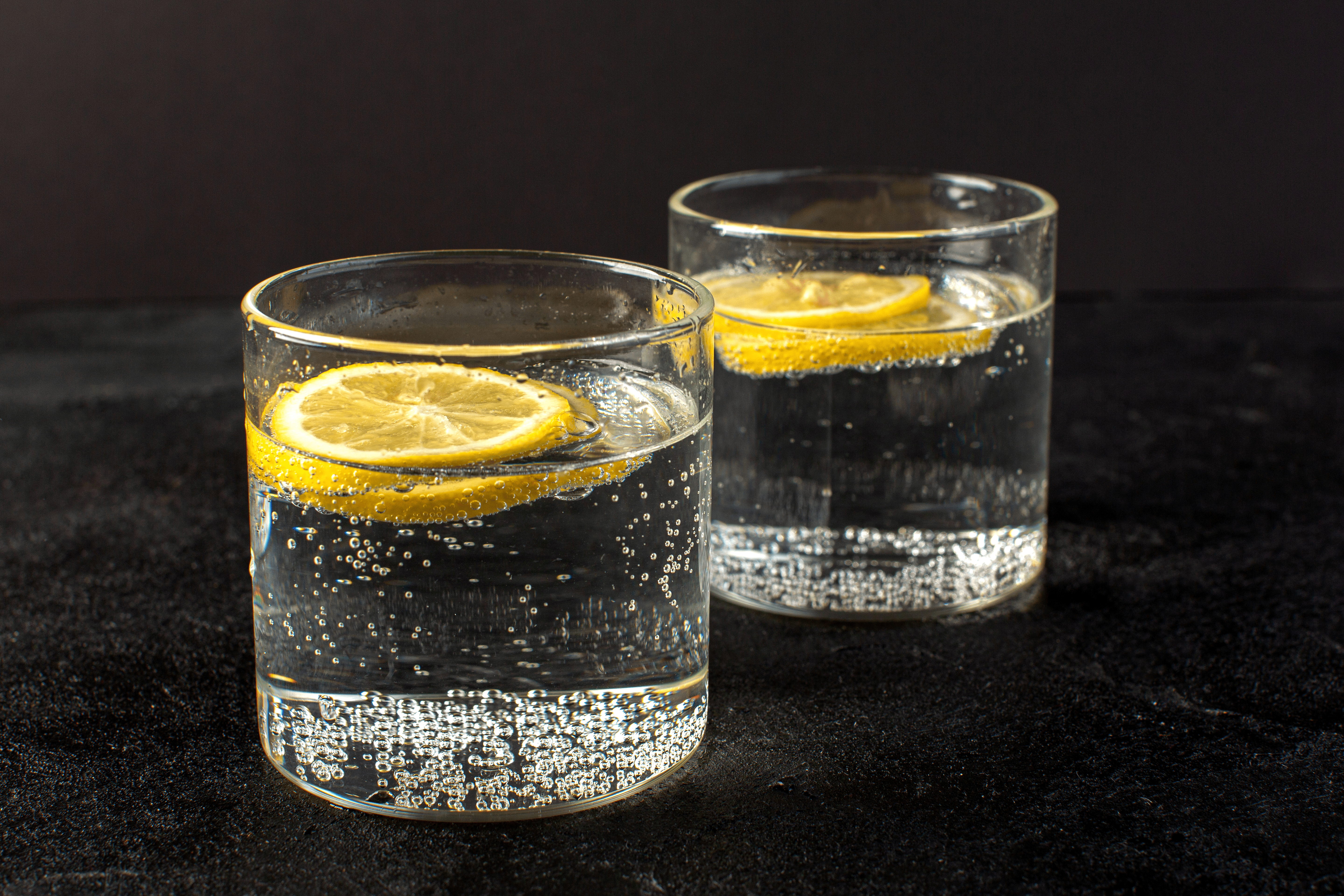 front-closed-up-view-water-with-lemon-fresh-cool-drink-with-sliced-lemons-inside-transparent-glasses
