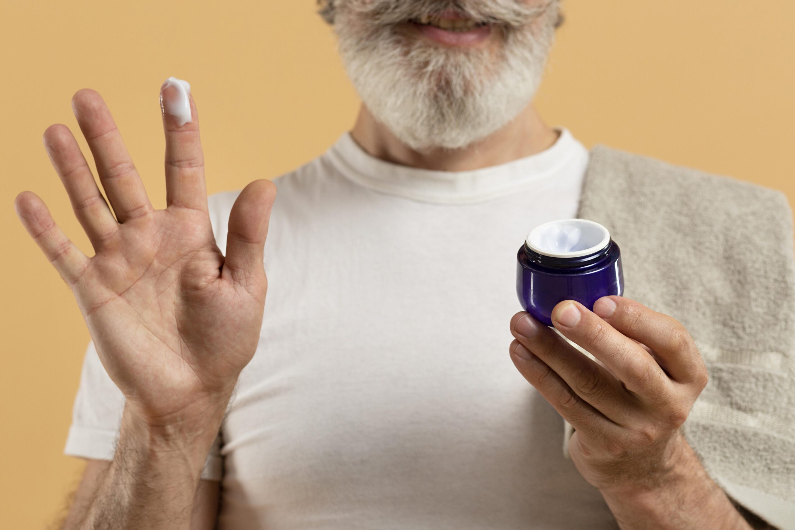 front-view-senior-man-with-beard-holding-moisturizer