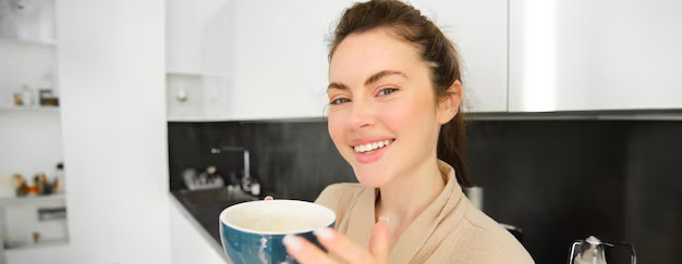 portrait-goodlooking-young-woman-starting-her-day-with-cup-coffee-standing-kitchen_1258-198144 (1)